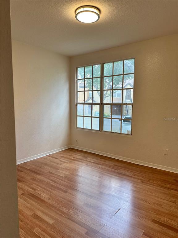 6304 Raleigh Street, Unit 202 Orlando, FL 32835 - Photo 9 of 15 an empty room with wooden floor and windows