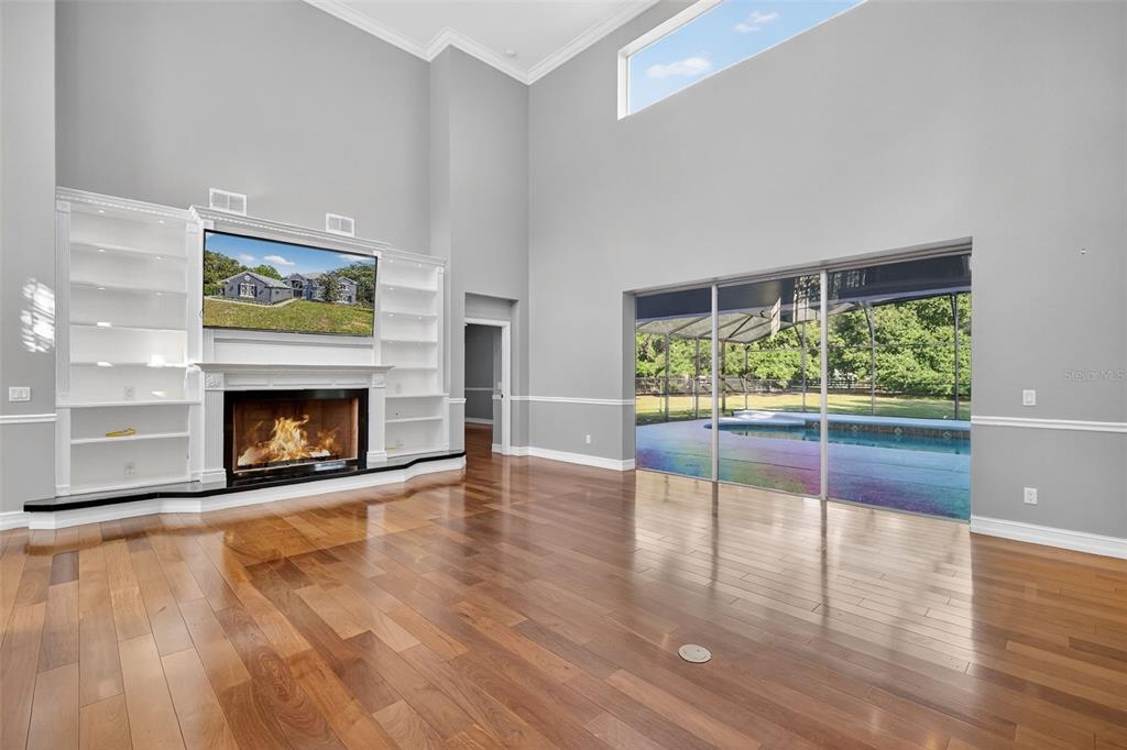 28004 Shirley Shores Road Tavares, FL 32778 - Photo 15 of 68 a view of an empty room with wooden floor fireplace and a window