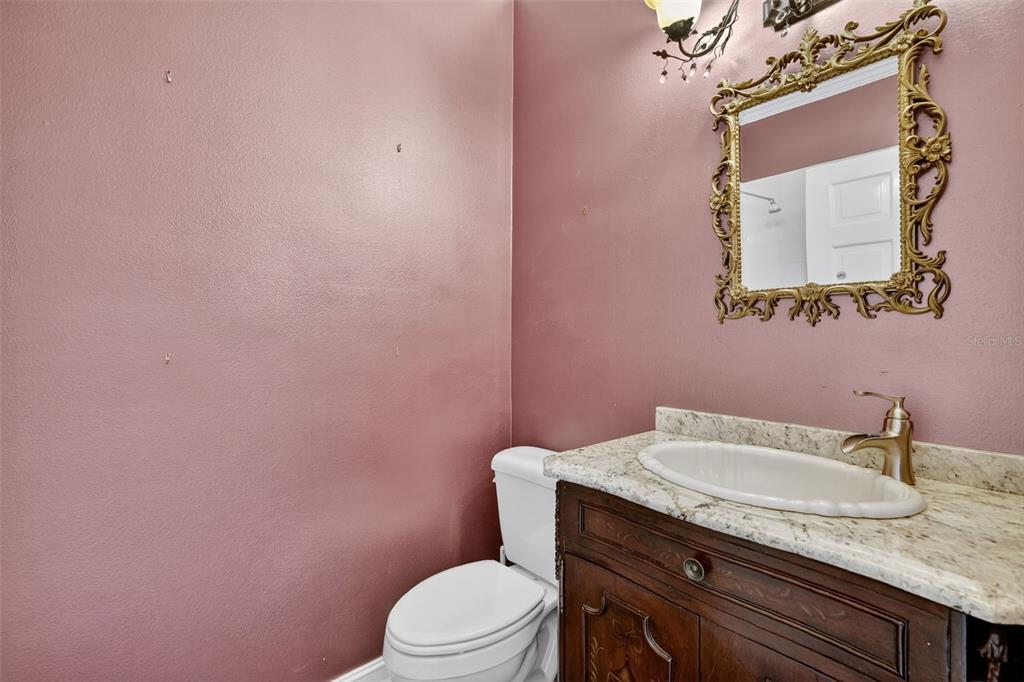 28004 Shirley Shores Road Tavares, FL 32778 - Photo 27 of 68 a bathroom with a granite countertop toilet sink and mirror