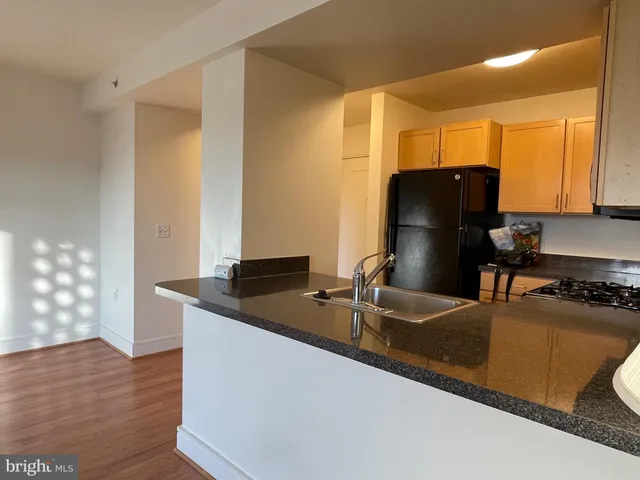 a kitchen with granite countertop a refrigerator and a sink