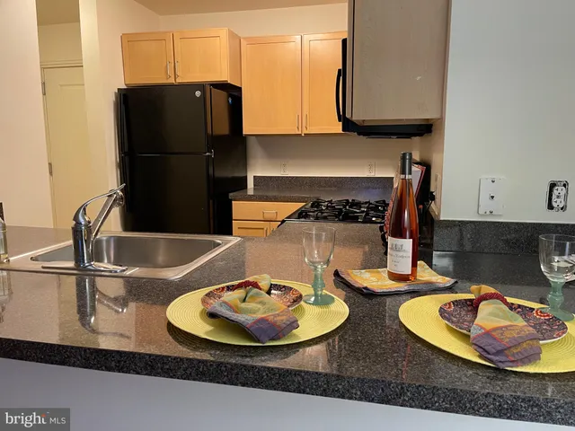 a kitchen with granite countertop a sink a stove and wooden cabinets