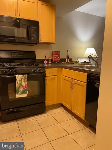 a kitchen with granite countertop a stove top oven and cabinets