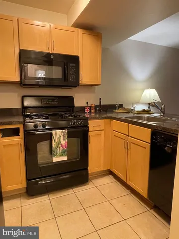 a kitchen with granite countertop a stove top oven microwave and cabinets