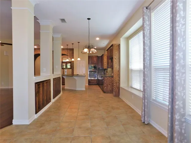 a view of a kitchen with refrigerator and a wooden floor