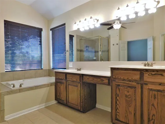 a bathroom with a granite countertop sink a large mirror and a bathtub