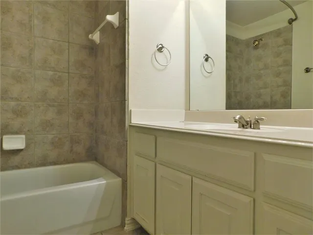 a bathroom with a tub a sink and mirror