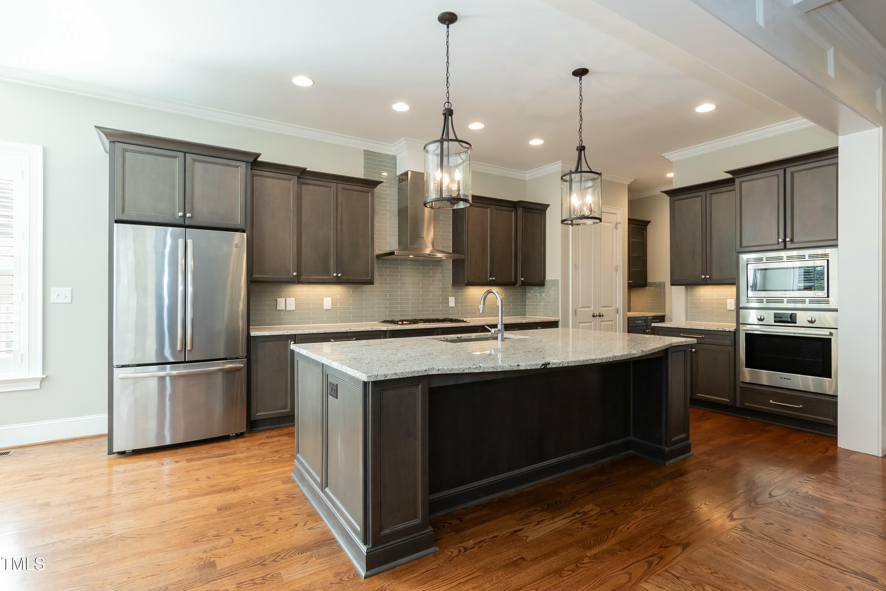6422 Rosny Road Raleigh, NC 27613 - Photo 9 of 39 a kitchen with kitchen island a sink stainless steel appliances and cabinets