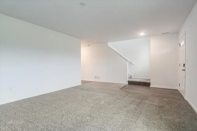 an empty room with staircase and white walls