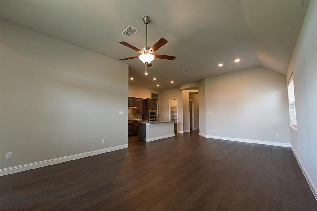 969 Canterbury Lane Forney, TX 75126 - Photo 11 of 24 an empty room with wooden floor and a ceiling fan
