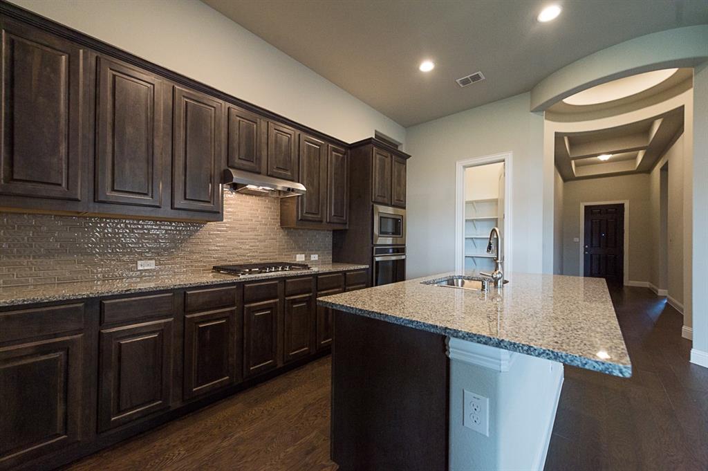 969 Canterbury Lane Forney, TX 75126 - Photo 5 of 24 a kitchen with granite countertop wooden cabinets and a stainless steel appliances