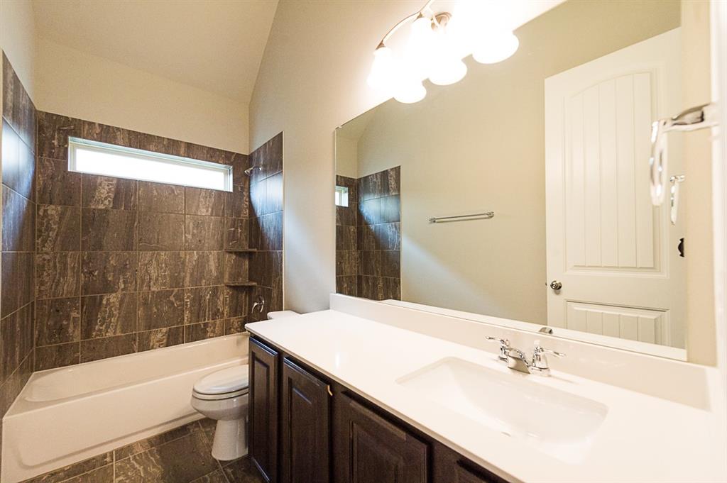 969 Canterbury Lane Forney, TX 75126 - Photo 10 of 24 a bathroom with a sink a toilet a mirror a bathtub and shower
