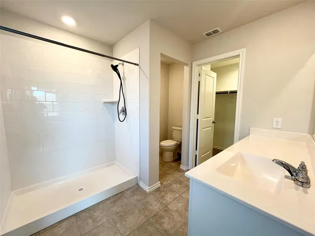a spacious bathroom with a granite countertop sink a mirror and a bathtub