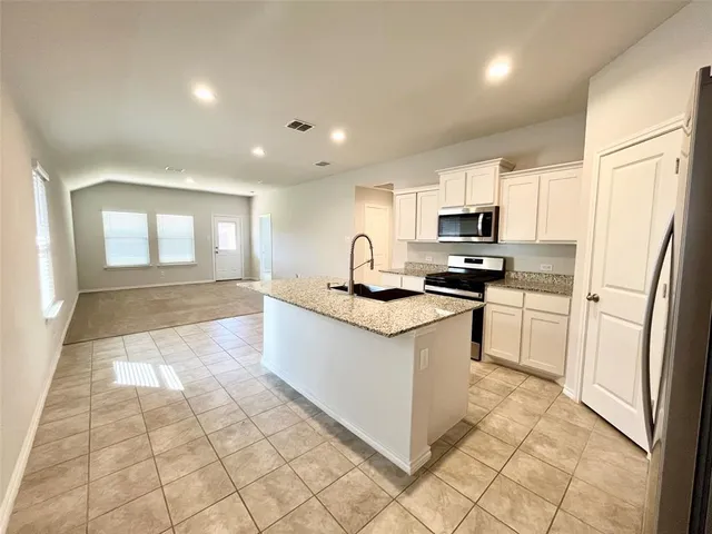 a kitchen with stainless steel appliances a refrigerator sink stove microwave and cabinets