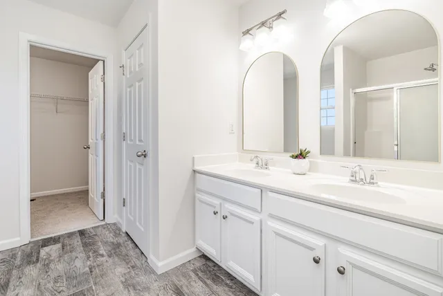 a bathroom with double vanity sinks and a mirror