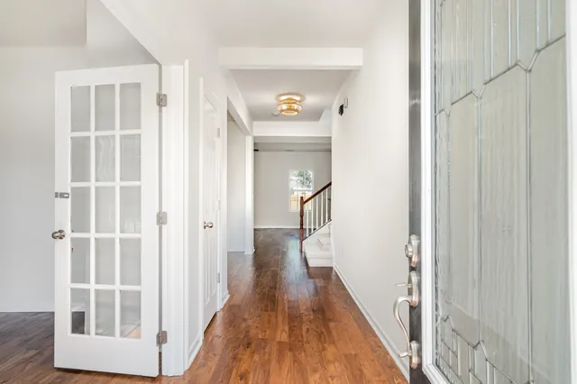 a view of a hallway with wooden floor and entryway