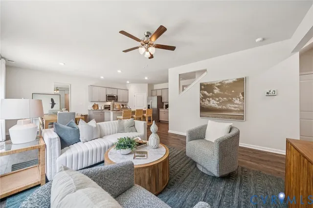 a living room with furniture and a view of kitchen