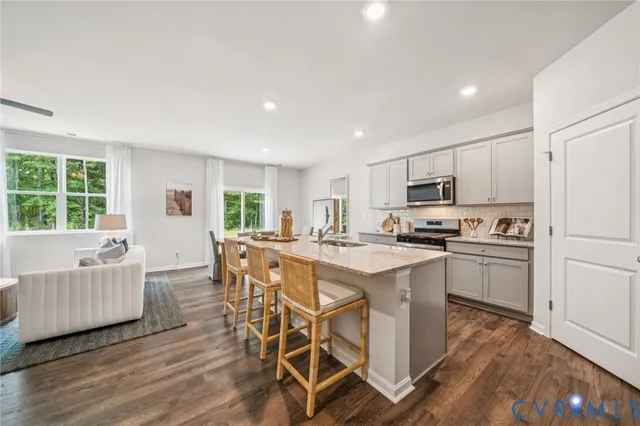 a kitchen with kitchen island granite countertop wooden floors and white appliances