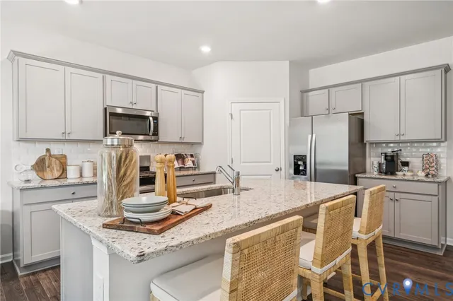 a kitchen with kitchen island granite countertop a sink stove and refrigerator