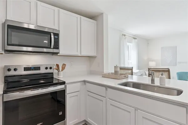 a kitchen with stainless steel appliances a stove microwave and sink