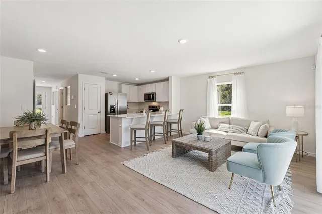 a living room with furniture kitchen and a table