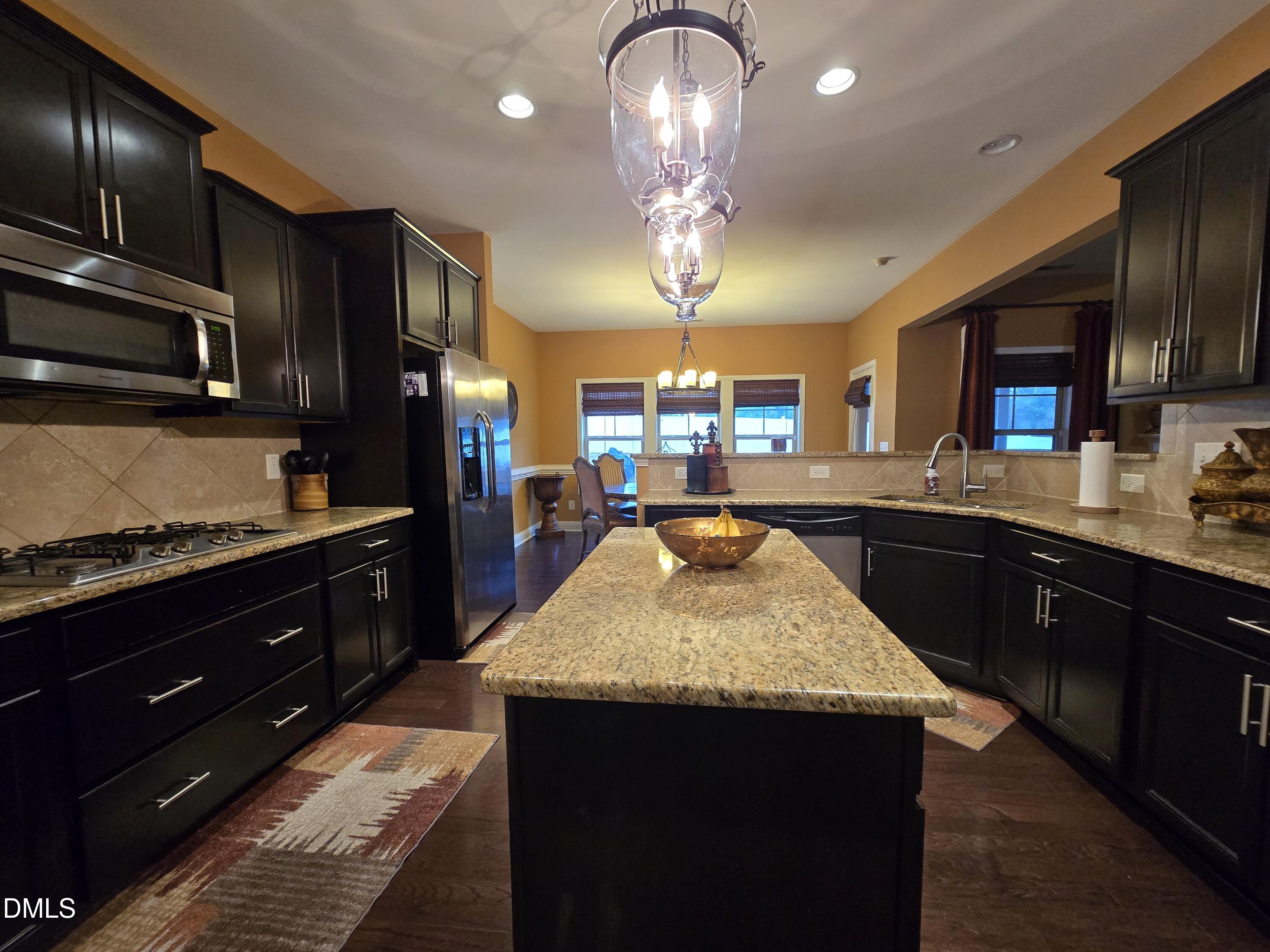 4202 Smithson Court Raleigh, NC 27616 - Photo 19 of 54 a kitchen with a sink stainless steel appliances and cabinets