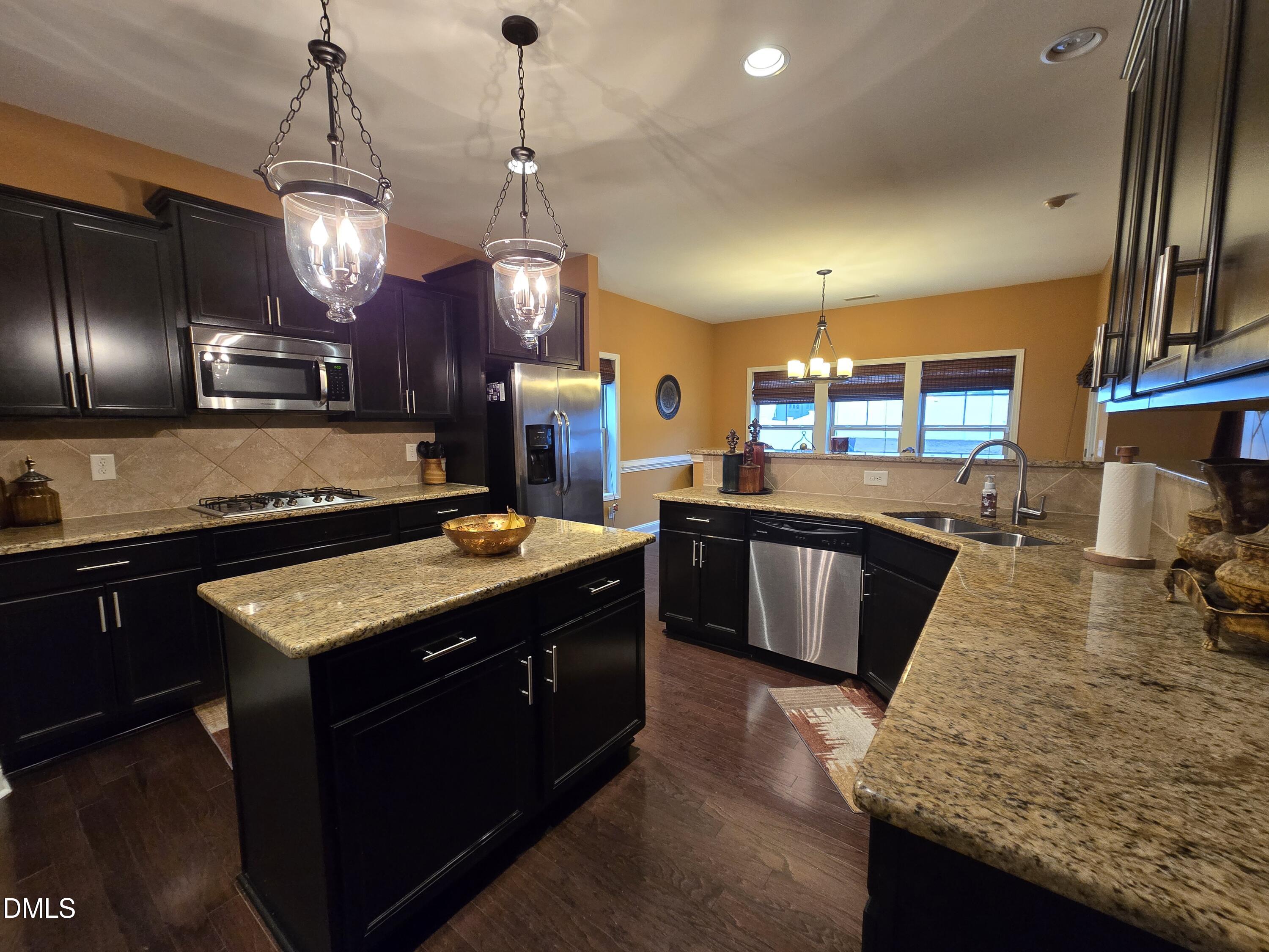 4202 Smithson Court Raleigh, NC 27616 - Photo 20 of 54 a large kitchen with stainless steel appliances granite countertop a stove refrigerator and wooden floor