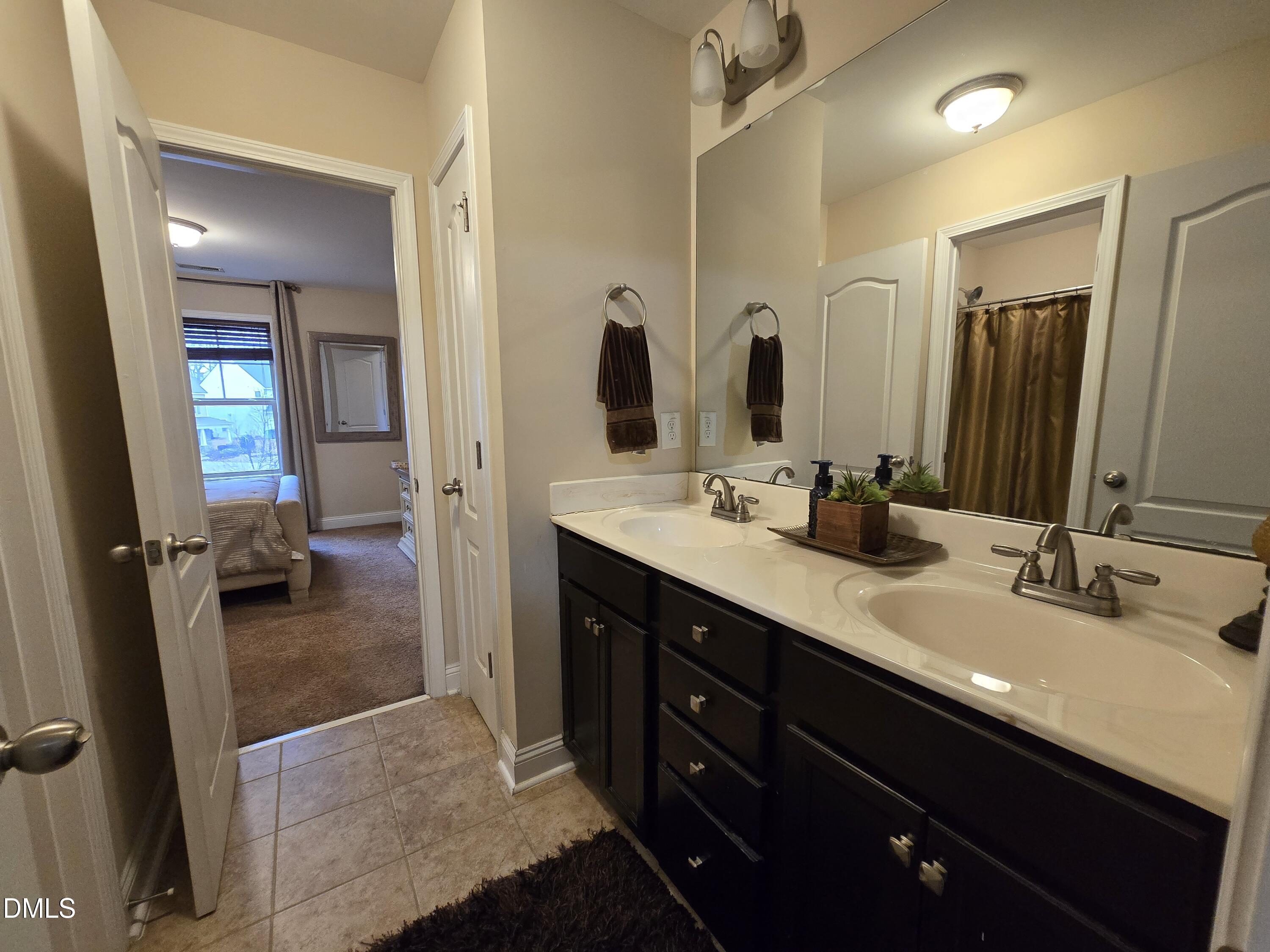 4202 Smithson Court Raleigh, NC 27616 - Photo 23 of 54 a en suite bathroom with double sink and a mirror