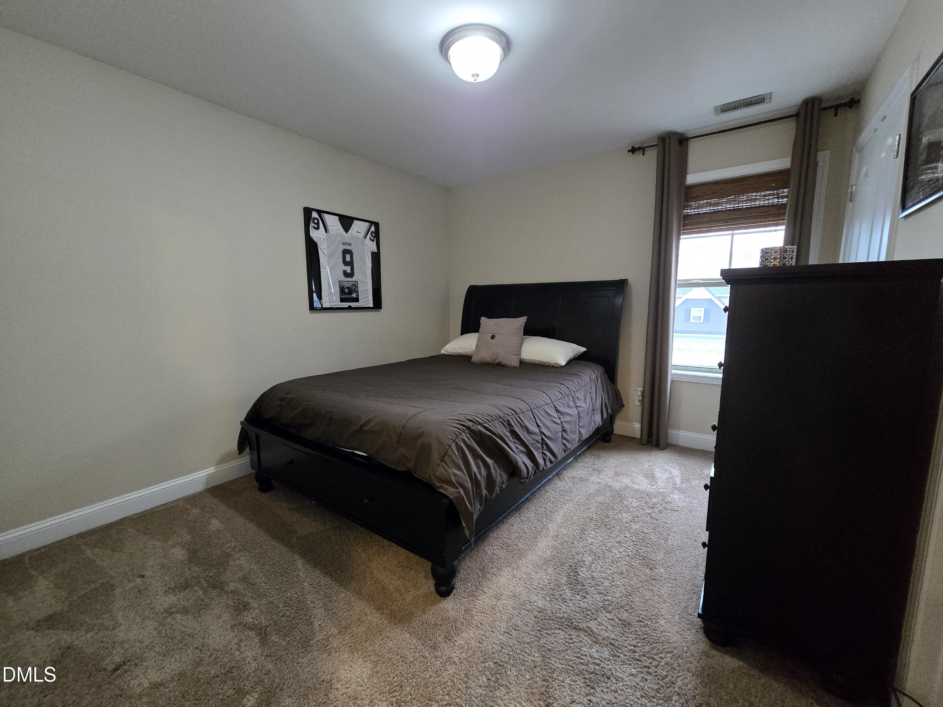4202 Smithson Court Raleigh, NC 27616 - Photo 25 of 54 a bedroom with a bed and a night stand