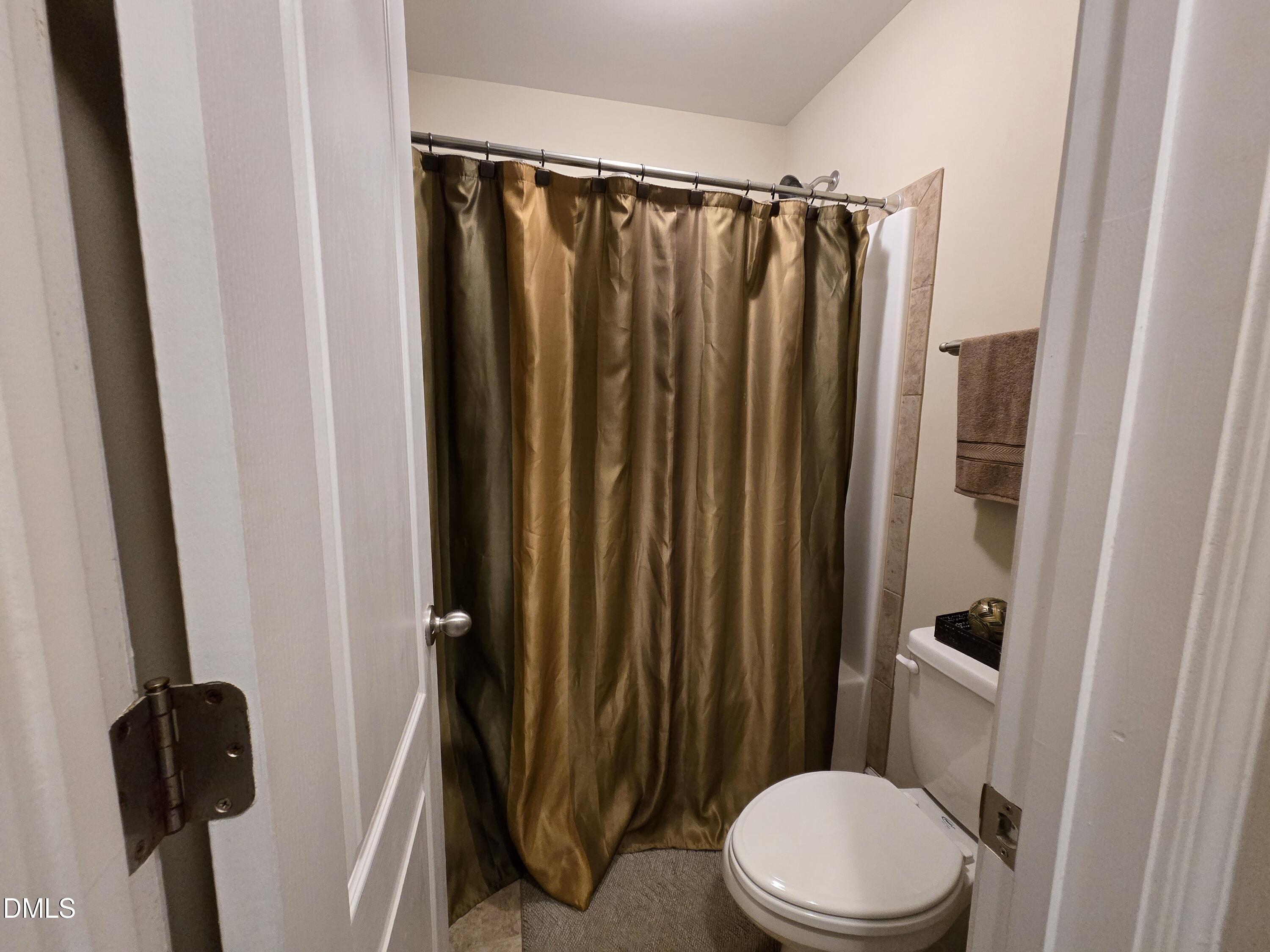 4202 Smithson Court Raleigh, NC 27616 - Photo 27 of 54 a bathroom with a sink a toilet a mirror and shower curtain