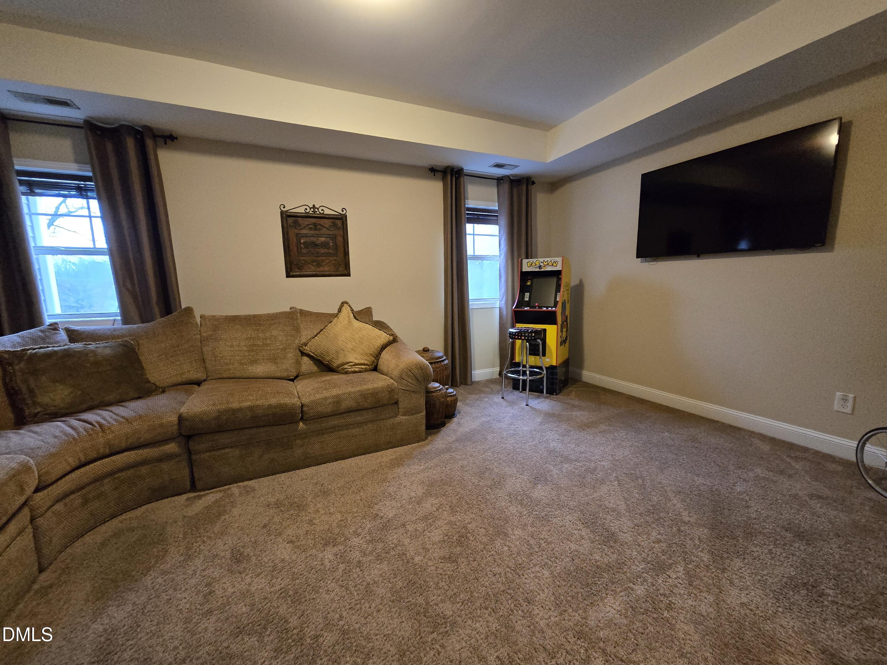 4202 Smithson Court Raleigh, NC 27616 - Photo 32 of 54 a living room with a flat screen tv a lamp and a window