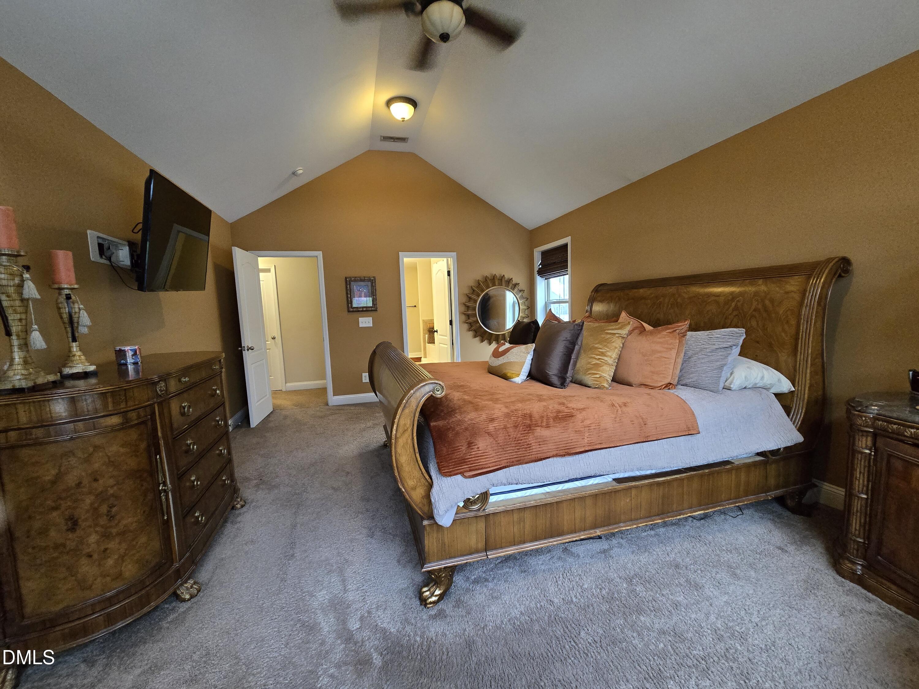 4202 Smithson Court Raleigh, NC 27616 - Photo 37 of 54 a spacious bedroom with a bed and a chandelier