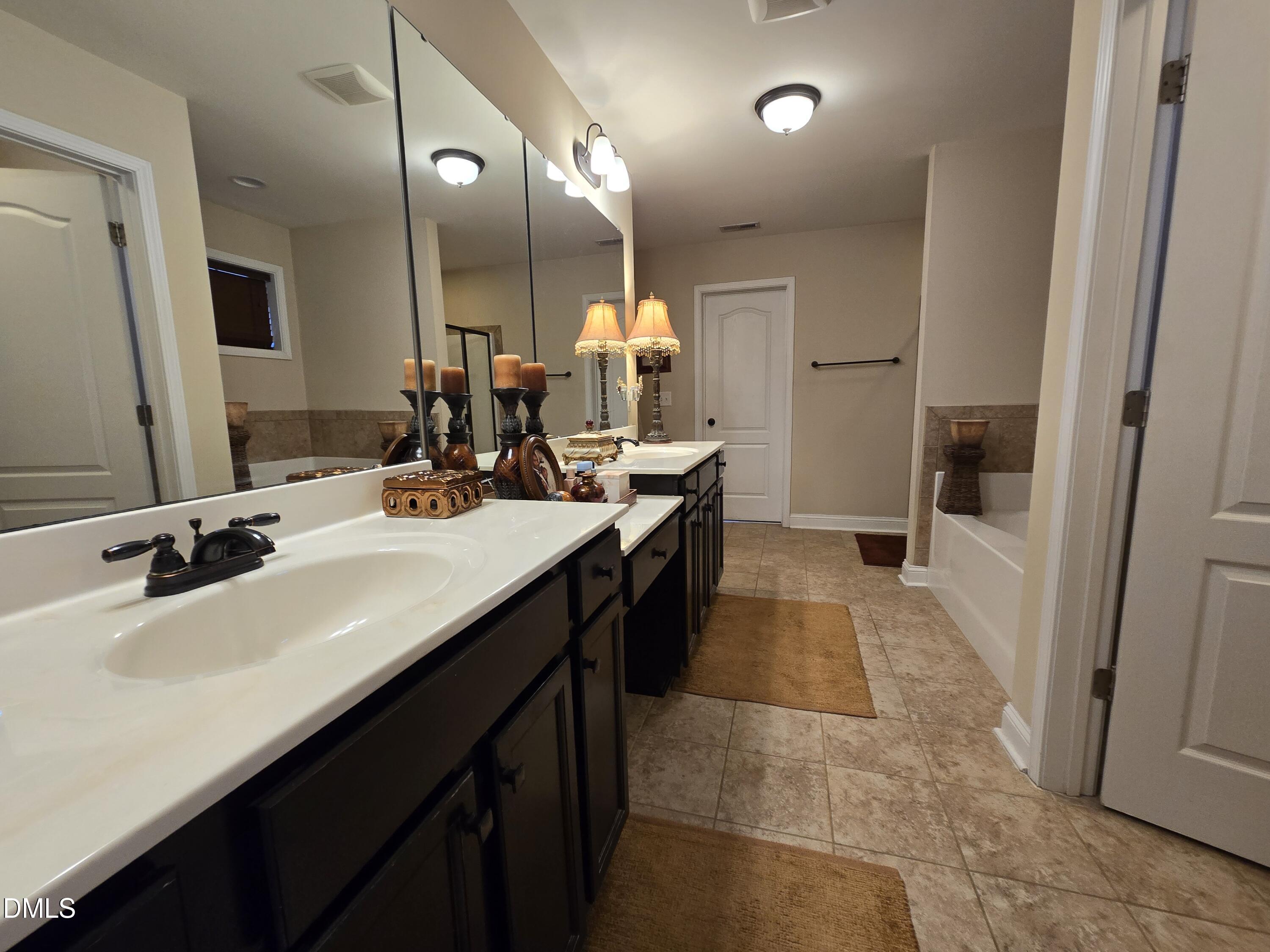 4202 Smithson Court Raleigh, NC 27616 - Photo 38 of 54 a bathroom with a double vanity sink a and mirror