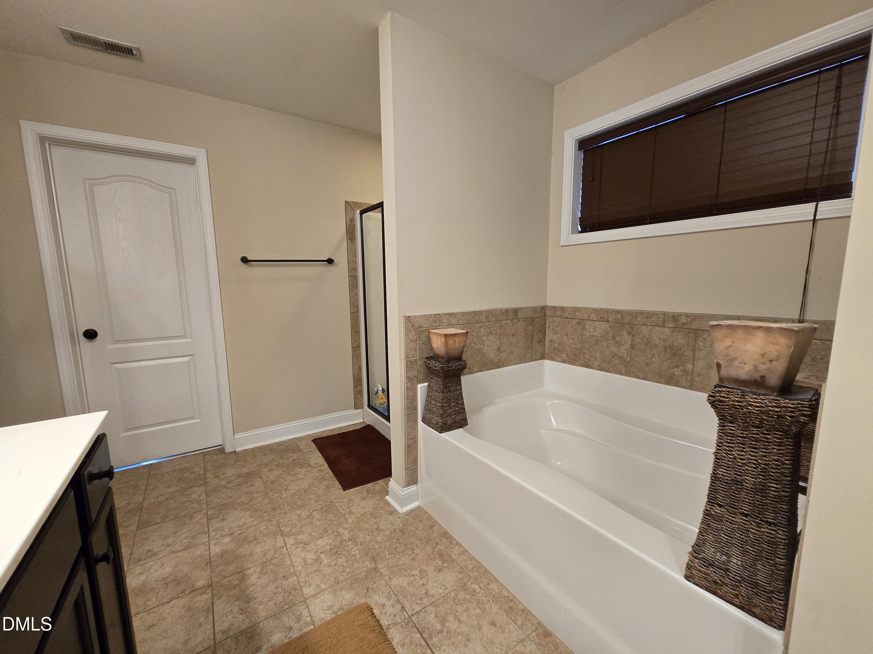 4202 Smithson Court Raleigh, NC 27616 - Photo 39 of 54 a bathroom with a bathtub and a shower