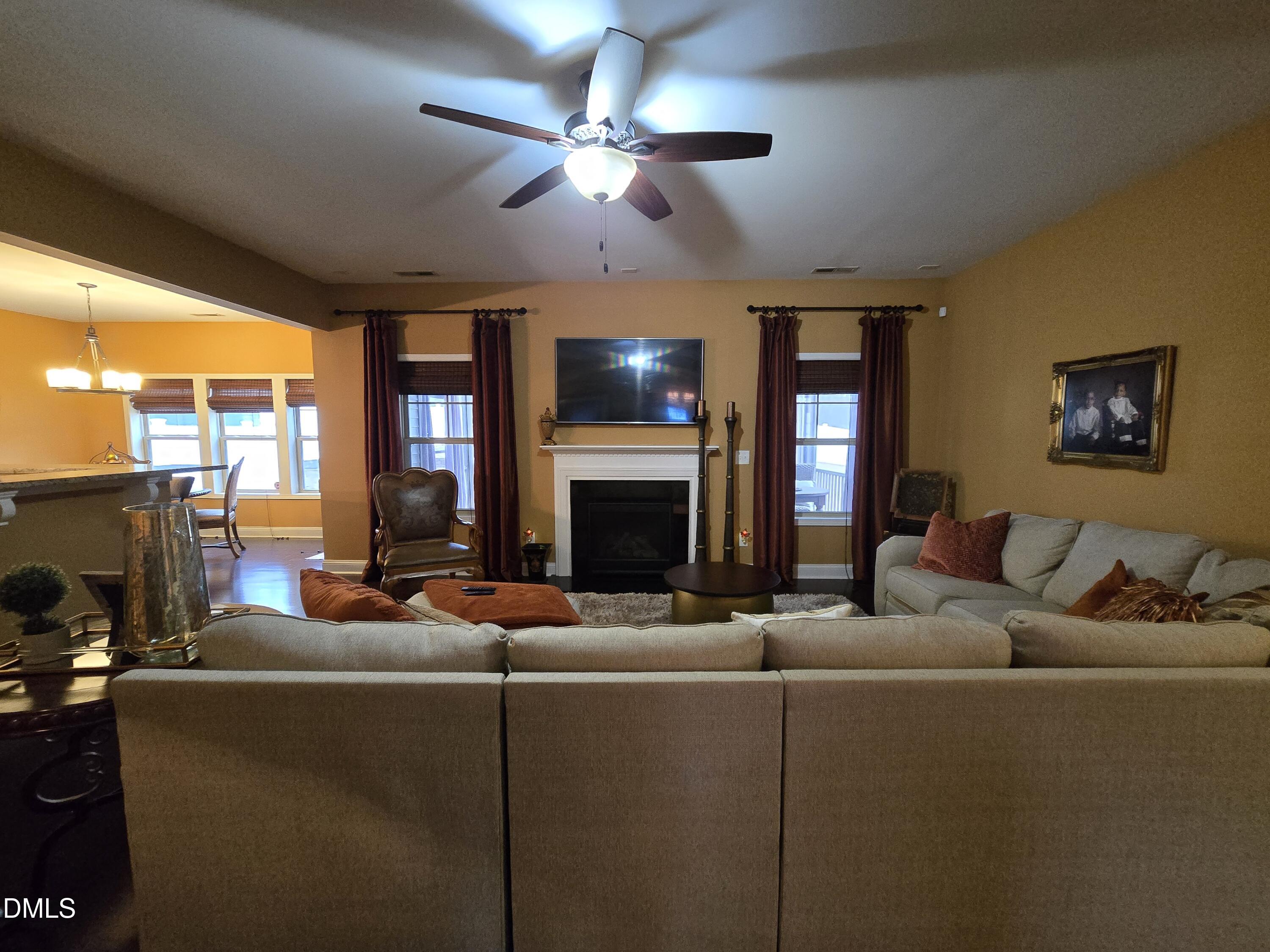 4202 Smithson Court Raleigh, NC 27616 - Photo 9 of 54 a living room with furniture a fireplace and a flat screen tv
