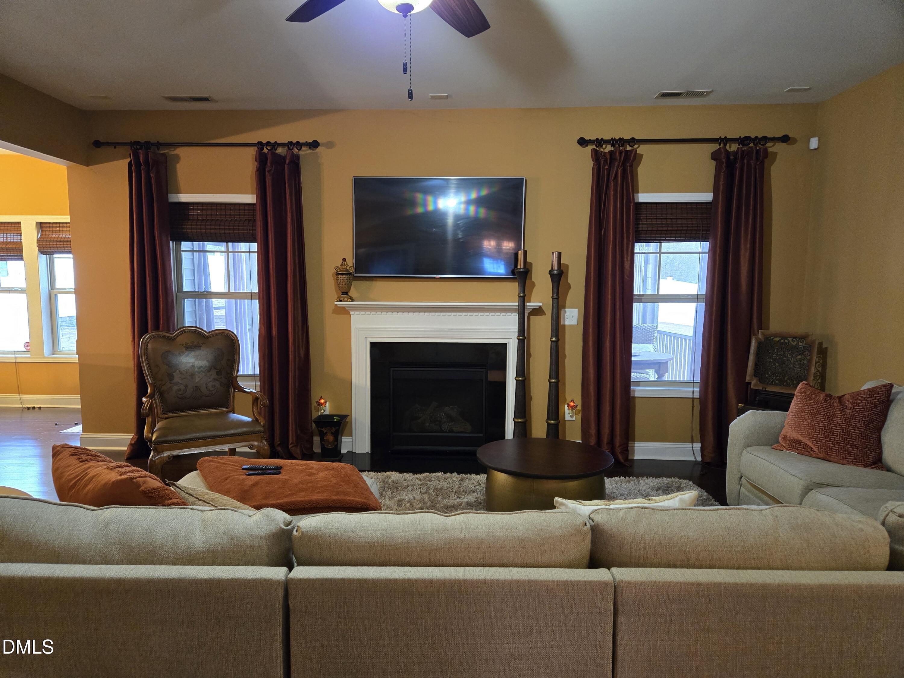4202 Smithson Court Raleigh, NC 27616 - Photo 10 of 54 a living room with furniture a flat screen tv and a fireplace