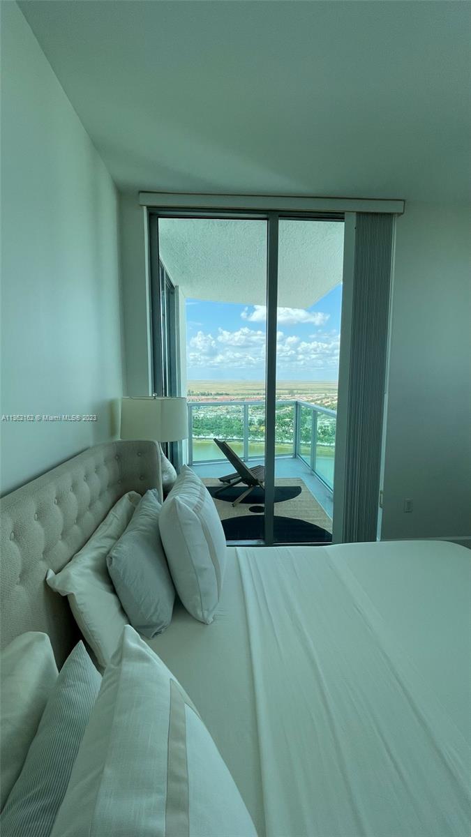 2681 North Flamingo Road, Unit 2408S Sunrise, FL 33323 - Photo 17 of 57 a bed sitting in a bedroom next to a large window