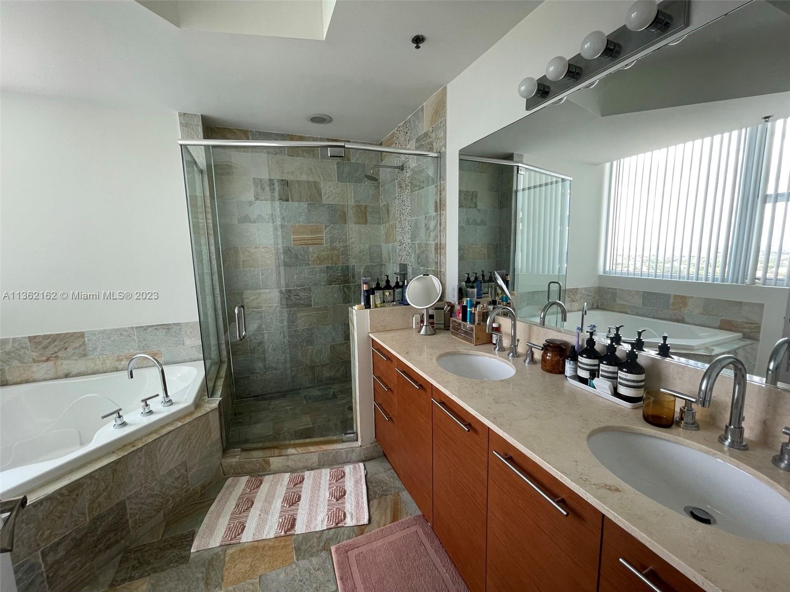 2681 North Flamingo Road, Unit 2408S Sunrise, FL 33323 - Photo 18 of 57 a bathroom with a tub sink toilet and mirror