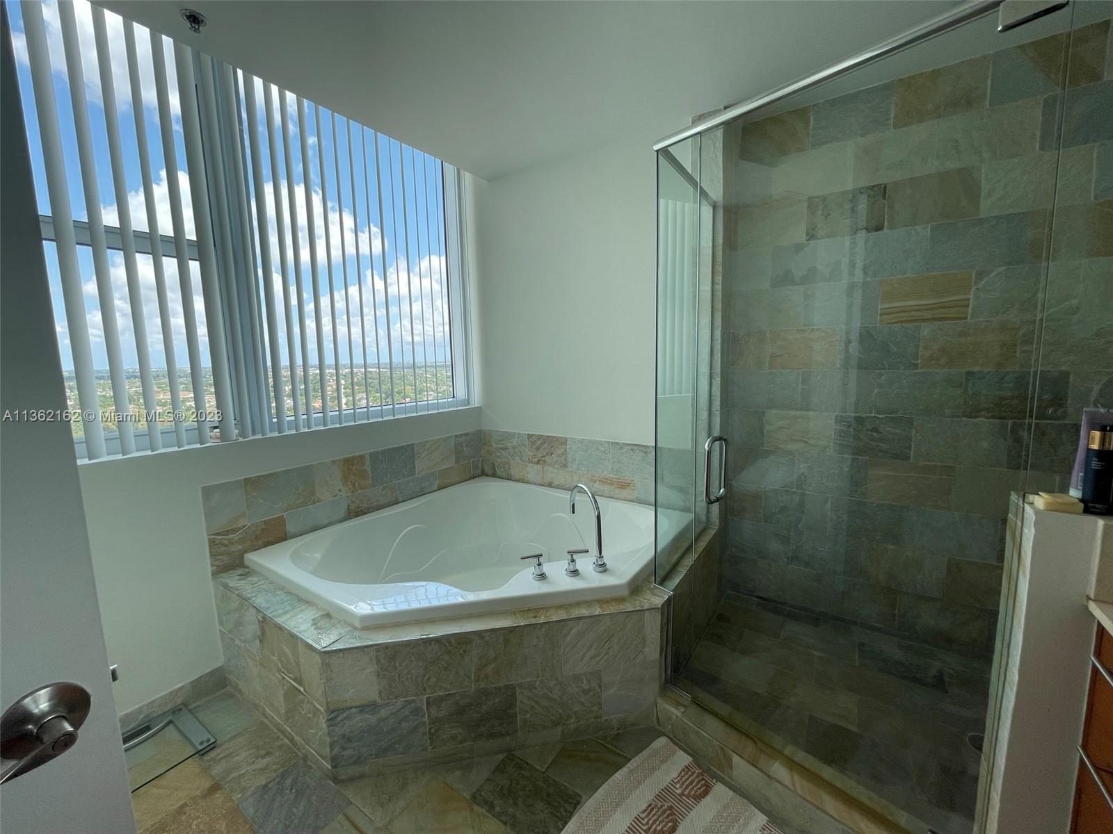 2681 North Flamingo Road, Unit 2408S Sunrise, FL 33323 - Photo 19 of 57 a bath tub sitting in a bathroom next to a sink