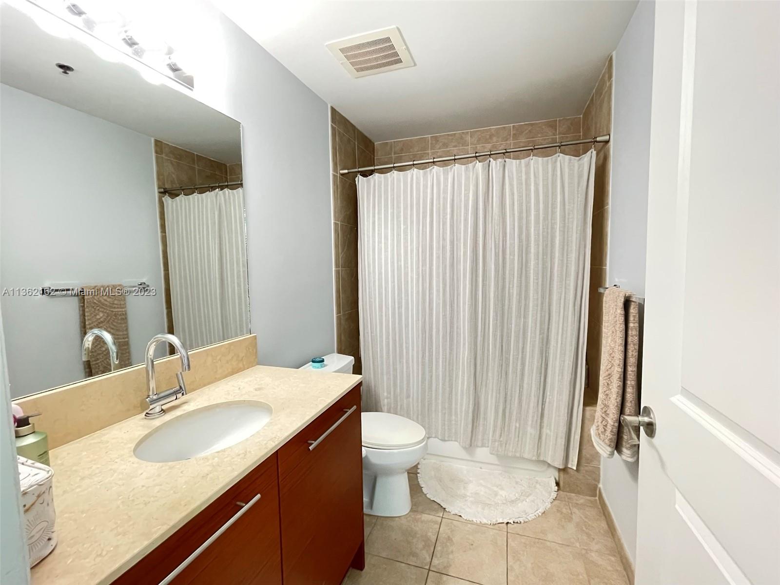 2681 North Flamingo Road, Unit 2408S Sunrise, FL 33323 - Photo 24 of 57 a bathroom with a double vanity sink toilet and a mirror
