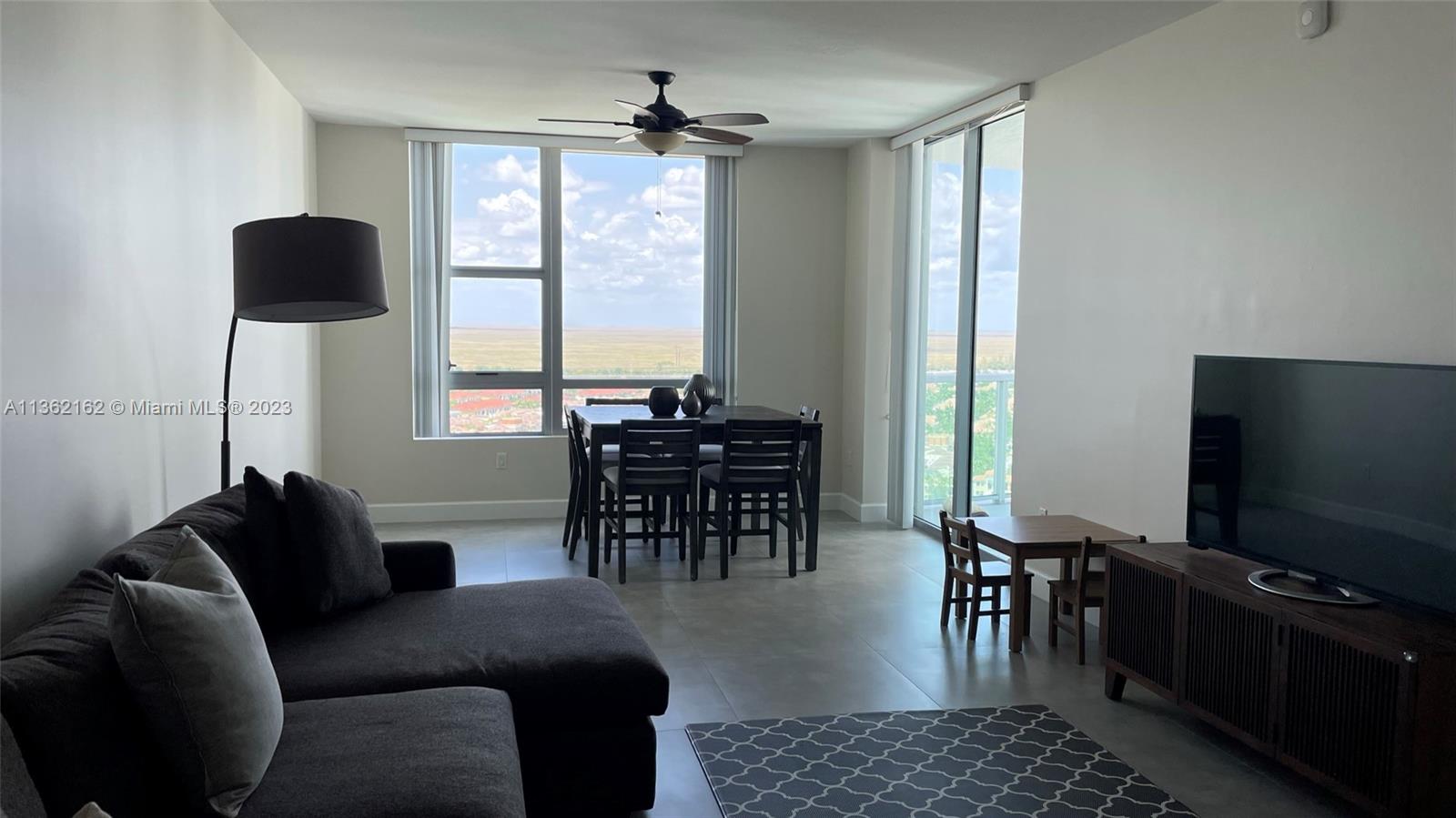 2681 North Flamingo Road, Unit 2408S Sunrise, FL 33323 - Photo 4 of 57 a living room with furniture and a flat screen tv