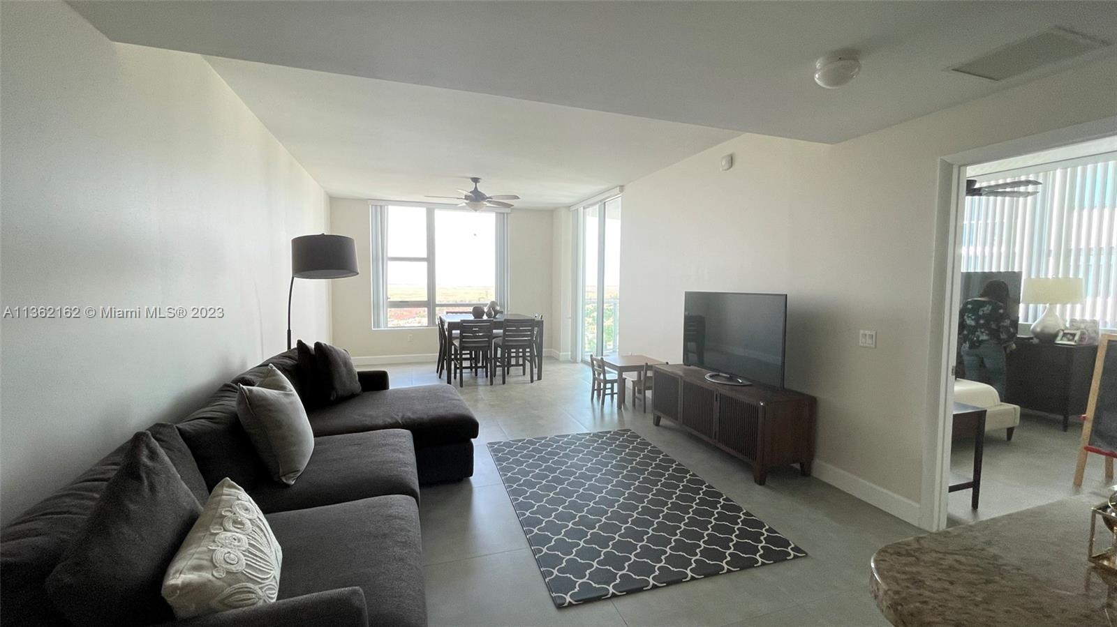 2681 North Flamingo Road, Unit 2408S Sunrise, FL 33323 - Photo 5 of 57 a living room with furniture and a flat screen tv