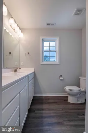 a bathroom with a toilet sink and mirror