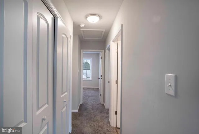 a view of a hallway with a door and a mirror