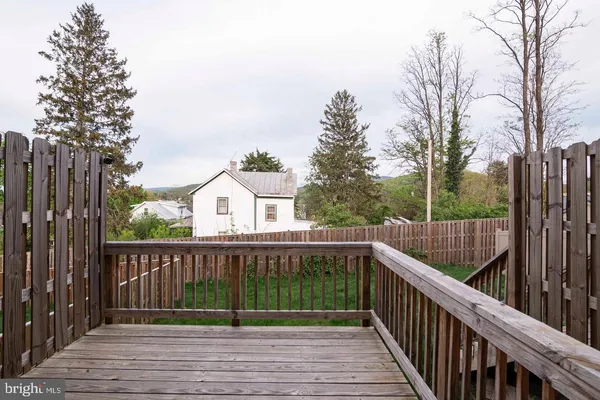 a view of deck with wooden fence and trees