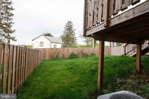 a view of a backyard with wooden fence and plants