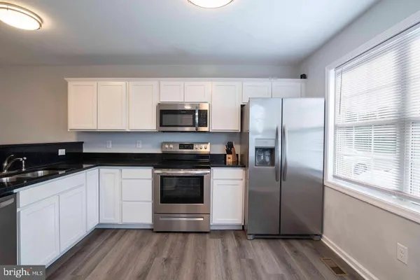 a kitchen with stainless steel appliances a refrigerator sink and microwave