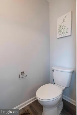 a white toilet sitting next to a white wall