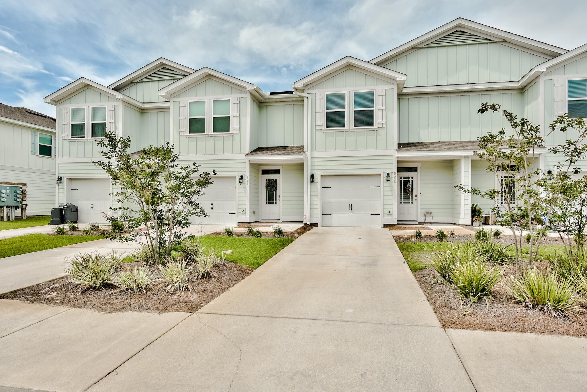 89 Crossing Lane, Unit C Santa Rosa Beach, FL 32459 - Photo 1 of 27 a front view of a house with a garden