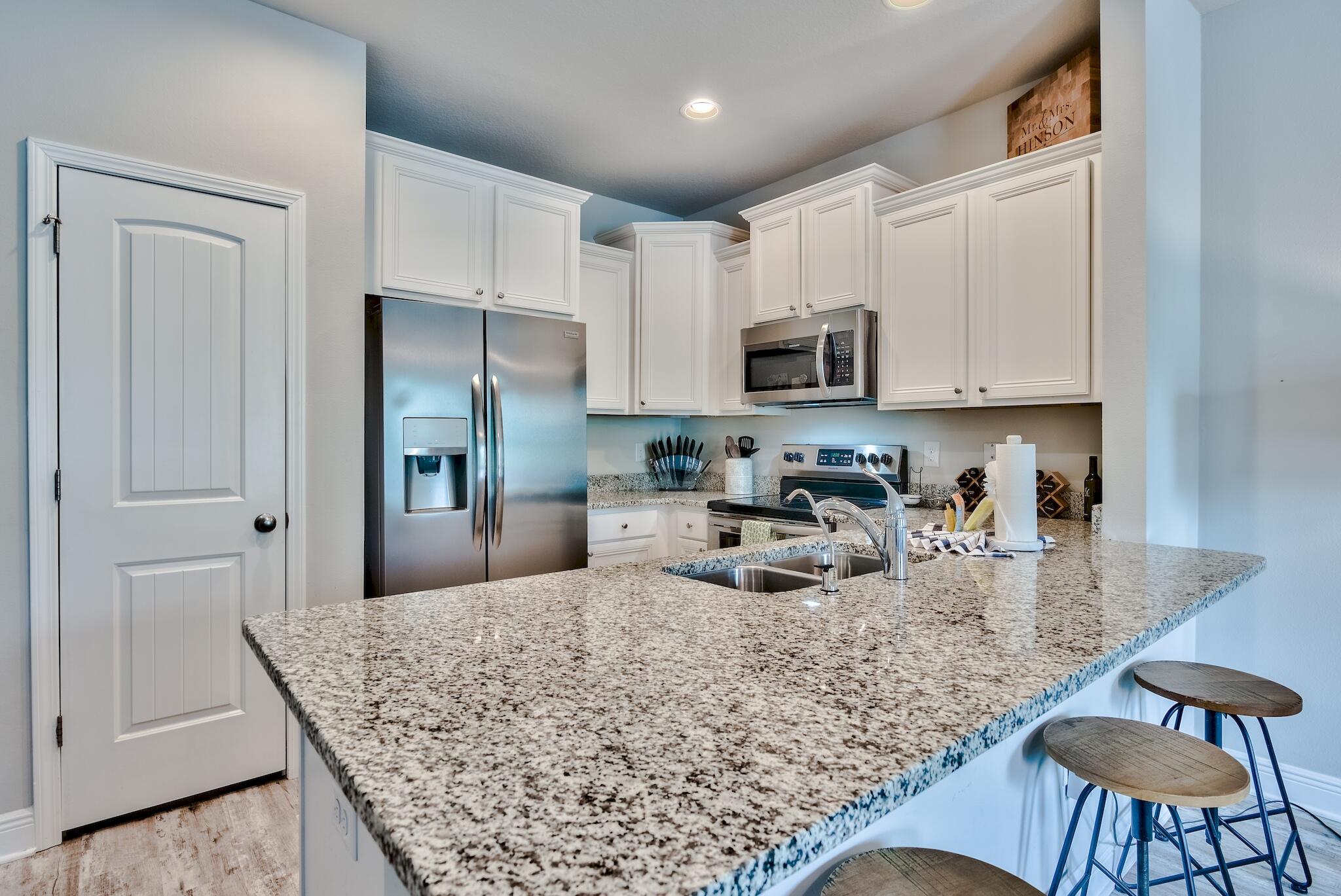 89 Crossing Lane, Unit C Santa Rosa Beach, FL 32459 - Photo 12 of 27 a kitchen with stainless steel appliances granite countertop a refrigerator sink and cabinets