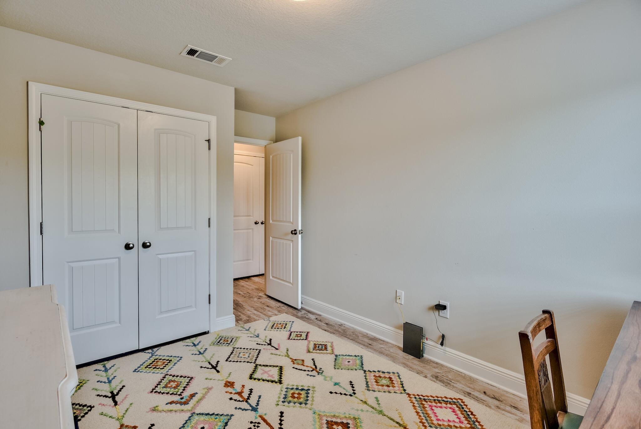 89 Crossing Lane, Unit C Santa Rosa Beach, FL 32459 - Photo 16 of 27 a bedroom with a bed and a wooden floor